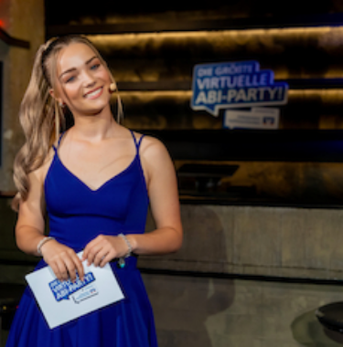Moderatorin Julia Beautx im blauen Kleid mit Moderationskarten
