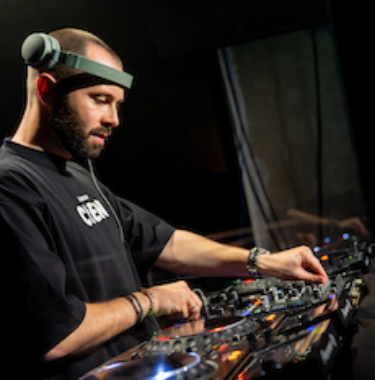 DJ David Puentez beim Auflegen am Mischpult mit Kopfhörern