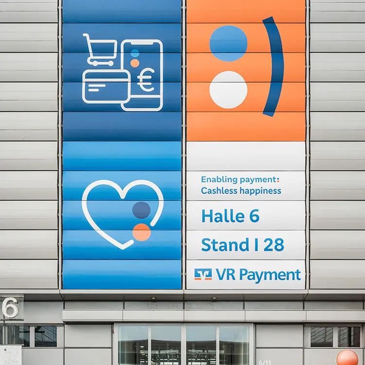 Fassadenbanner von VR Payment an Messehalle mit Symbolen und Hinweis auf Halle 6, Stand I 28.