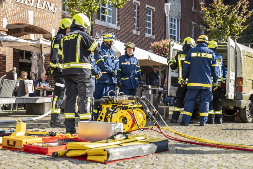 Einsatzkräfte des Technischen Hilfswerks (THW) demonstrieren schweres Rettungsgerät in Aktion, um Besucher*innen praktische Einblicke in die Arbeit im Bevölkerungsschutz zu geben.