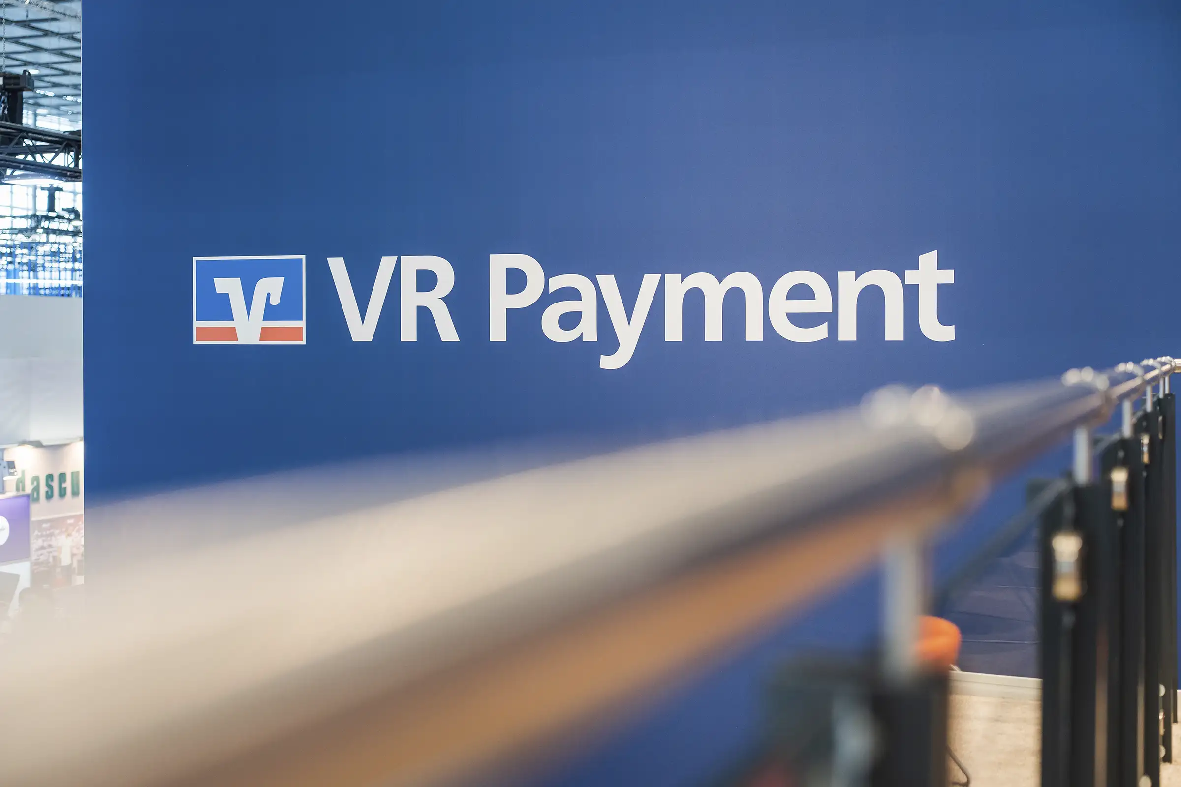 VR Payment Logo angebracht an einer Wand des Messestands