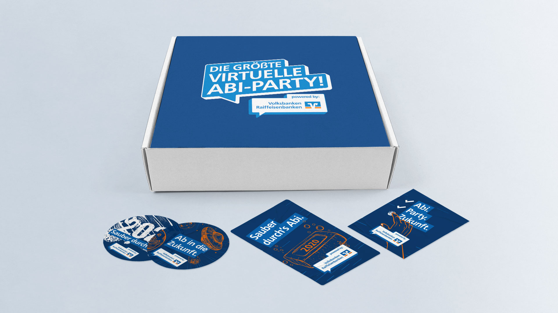 Blaue Box mit Aufdruck „Die größte virtuelle Abi-Party!“ und beigelegten Stickern und Karten zur Aktion.