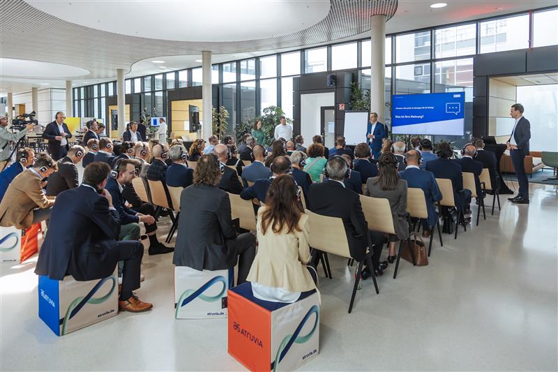 Teilnehmende sitzen in einem offenen Raum vor einer Präsentation mit großer Leinwand beim SHR 24-Event.